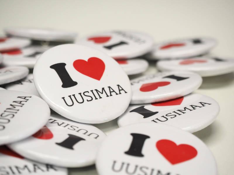 Valkoisia pyöreitä rintanappeja, joissa teksti I love Uusimaa.